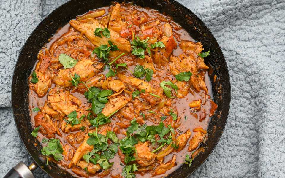 Rich slow-cooked meat curry in a bowl with garnish.