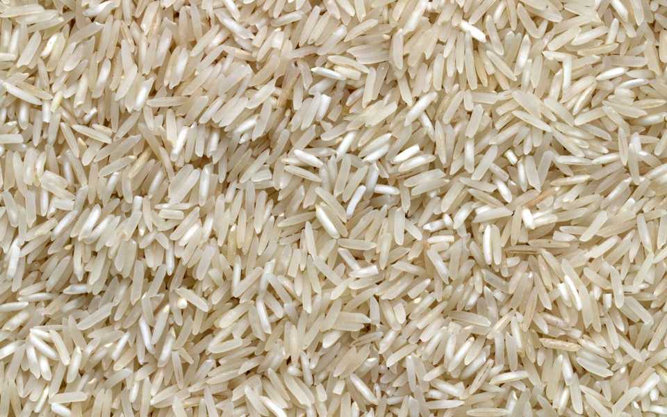 Bags of basmati rice and grain stacked on display.